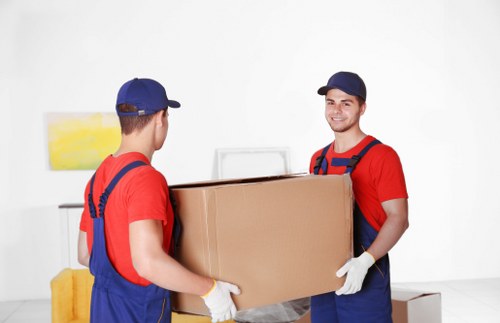 Local removals crew navigating a Bow street with furniture and packing cases