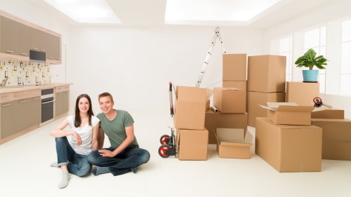 Movers carrying furniture through a residential property in Bow