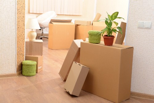 Packed moving boxes and furniture ready for collection in a Bow property