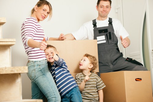 Removal team navigating a Bow apartment building with furniture and boxes